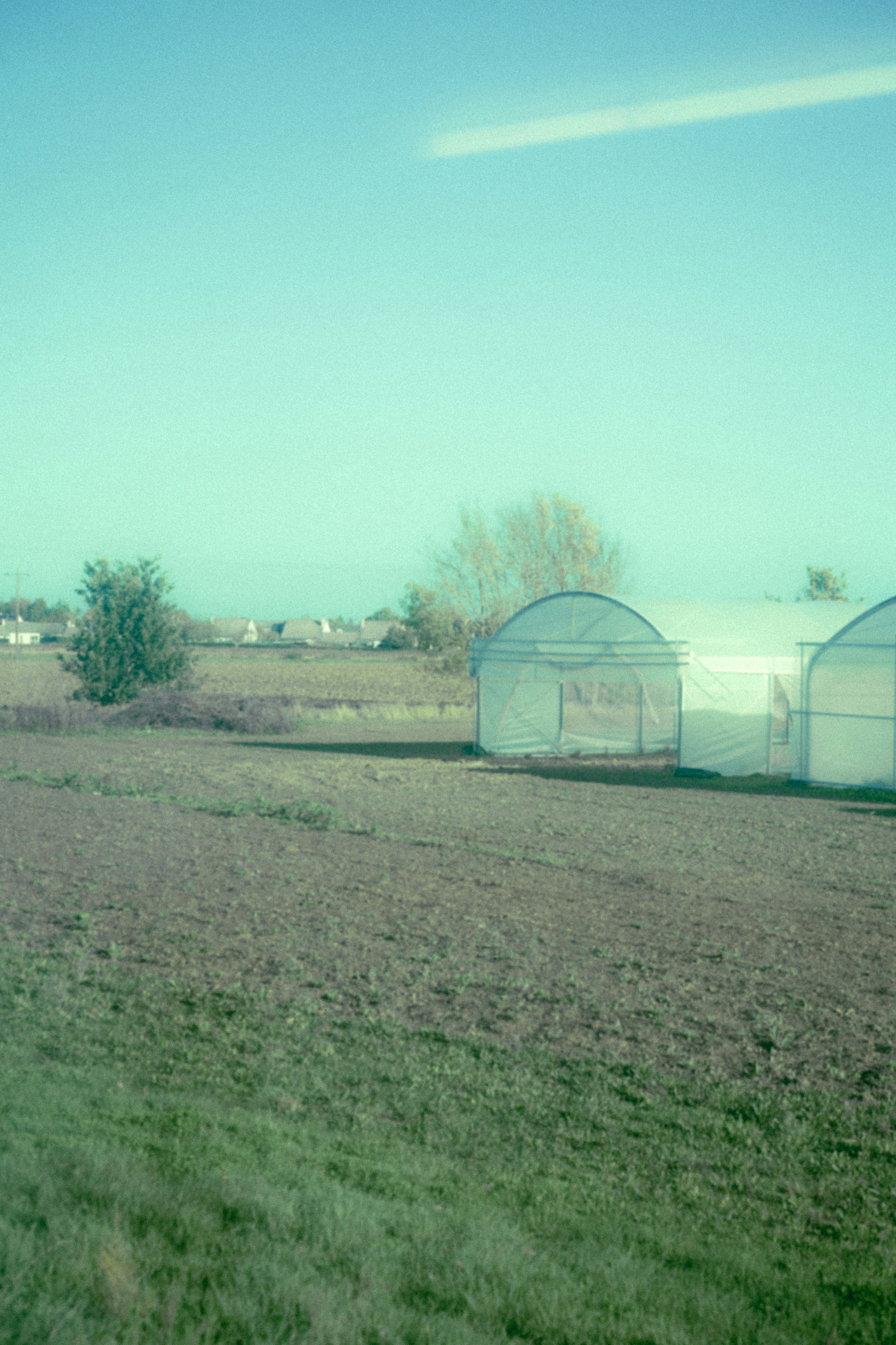 a large field with a couple of buildings in the background